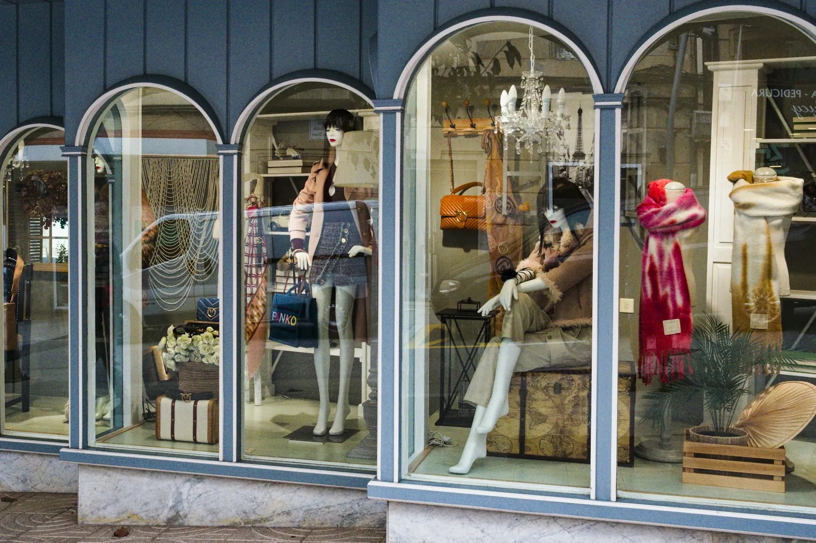 Mode-Schaufenster mit Mannequins unter Rundbogen-Fenstern